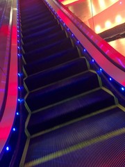 Colorfully lit escalator steps.