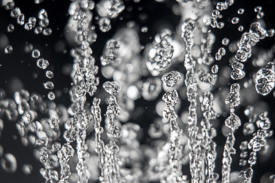 Drops of water levitation on black background, macro image. Frozen water .