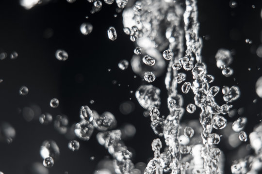 Drops of water levitating with defocused drops on background