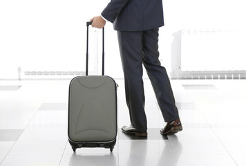 Man holding suitcase on light background