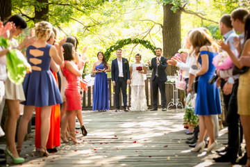 outdoor wedding ceremony at park with lot of guests