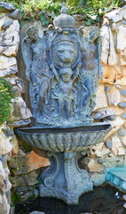 Fototapeta na wymiar Ancient copper fountain with sculptures