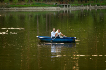 young bride and groom riding on the boat on lake