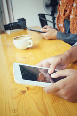 Male and female couple with tablet sitting indoor in trendy urban cafe.