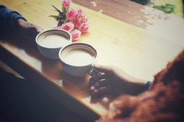 Male and female couple with latte coffee and rose