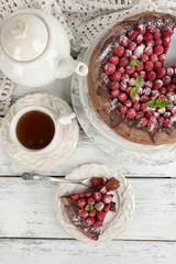 Piece of cake with chocolate Glaze and raspberries on color wooden background