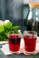Sweet homemade cherry juice on table, on color wooden background
