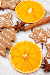 Fresh baked decorated gingerbread with spices on old wooden background, christmas time