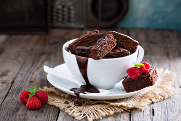 Brownies in stacked coffee cups with chocolate sauce