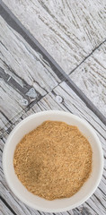 Lemongrass powder in a white bowl over wooden background
