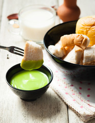 Thai dessert , Slice steamed bread and pandan custard on wood