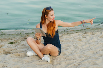 Redhead sexy woman with tablet computer.