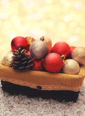 Christmas balls decorations with pine cone in box over golden ga
