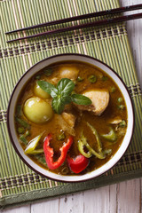 Thai cuisine: green curry chicken close-up. vertical top view

