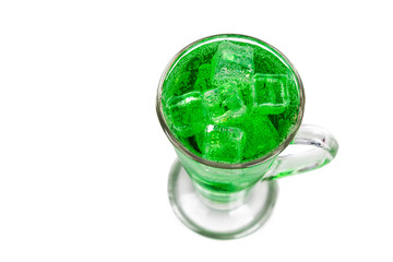 Refreshing green fizzy soft drink with ice in transperant glass