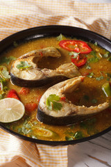 Indian fish curry with vegetables close-up. Vertical
