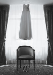 Room of the bride, wedding dress and shoes on chair