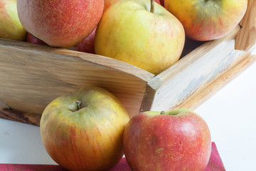 Pommes de couleurs différentes en vrac dans un panier sur fond blanc