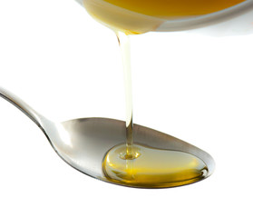 Pouring oil on spoon isolated on white,
