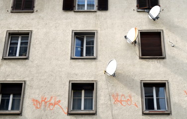 Schäbige Hausfassade mit Satellitenschüsseln