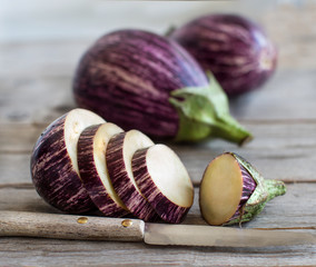 Fresh Raw striped eggplants and slices with knife