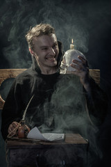 Halloween. Laughing monk with a skull in his hand.