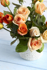 Bouquet of orange roses in basket on blue wooden background