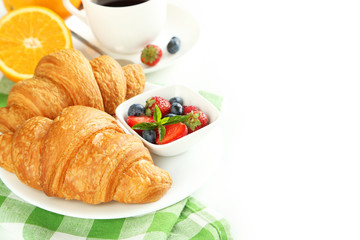 Fresh tasty croissants with berries on white background