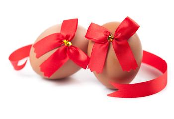 easter egg wrapped around red ribbon bow over white background