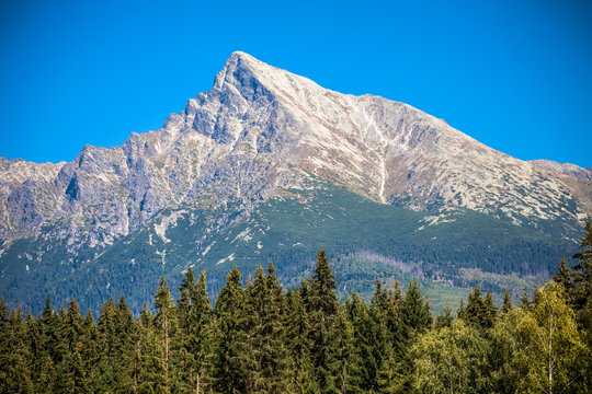 Krivan peak in High Tatras, Slovakia, iconic mountain landscape with forest and clear blue summer sky