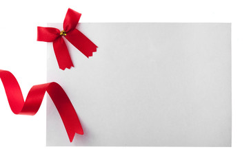 Shiny red ribbon with card isolated on white