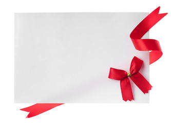 Shiny red ribbon with card isolated on white
