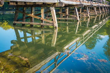 Reflection of the old medieval wooden bridge in the river.