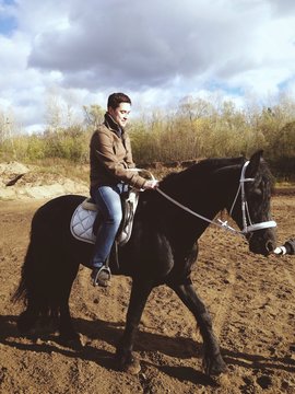Young man learns to ride a horse