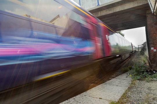 Train speeding in blur under bridge