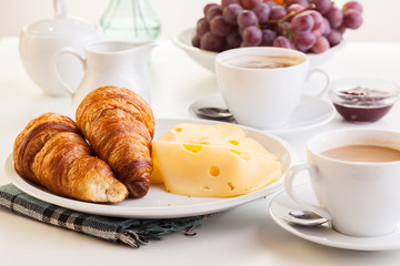 Croissants with cheese, fruits and coffee