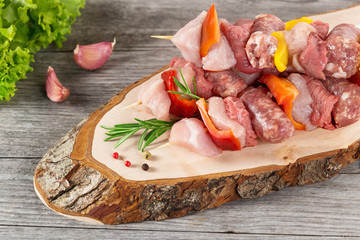 cutting board with meat skewers on wooden table