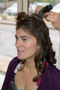 Stylist pinning up a woman's hairstyle at a beauty saloon