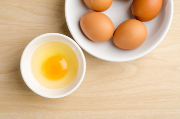 Fresh egg yolk in the bowl on wooden background,food ingredient