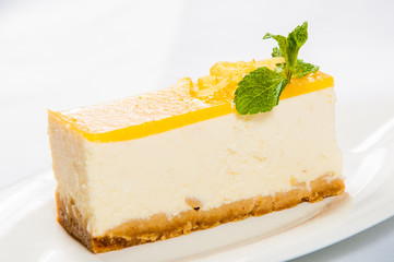 Lemon tart on a plate with fresh mint leaf