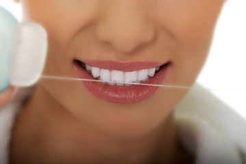 Woman using dental floss.