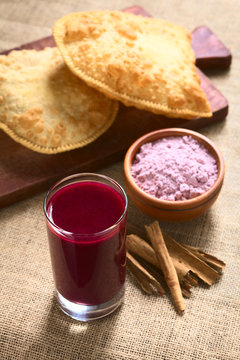 Traditional Bolivian Api purple corn beverage, with pastel (deep-fried pastry filled with cheese), photographed with natural light (Selective Focus, Focus in middle of drink's surface)