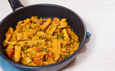 meat with rice and vegetables in a frying pan