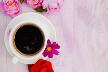 White cup of black coffee and rose petals beside instead of cake