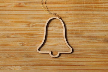 Wooden bell - christmas tree decoration on a wooden background.