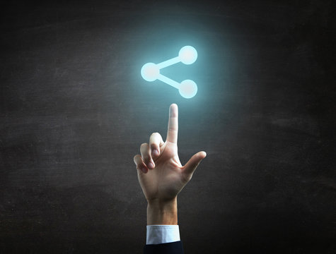 Businessman is indicating a blue share icon on black blackboard