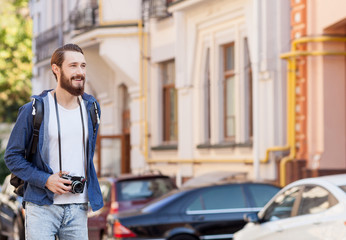 Cheerful young man is traveling across town