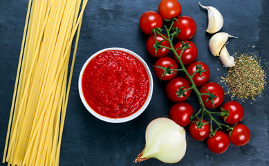 Ingredients for Spaghetti with marinara sauce.  Ready to Cook. On blue background