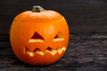 Scary Jack O Lantern halloween pumpkin on old wooden table