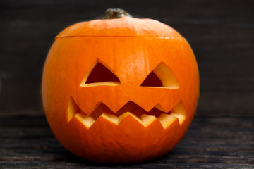 Scary Jack O Lantern halloween pumpkin on old wooden table